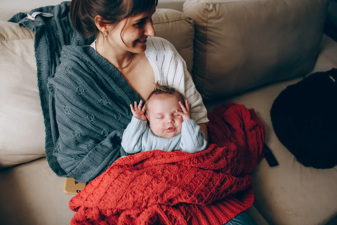 Verzorger houdt een slapende baby vast