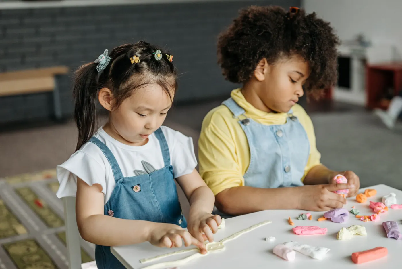 Twee kinderen werken samen met klei aan tafel
